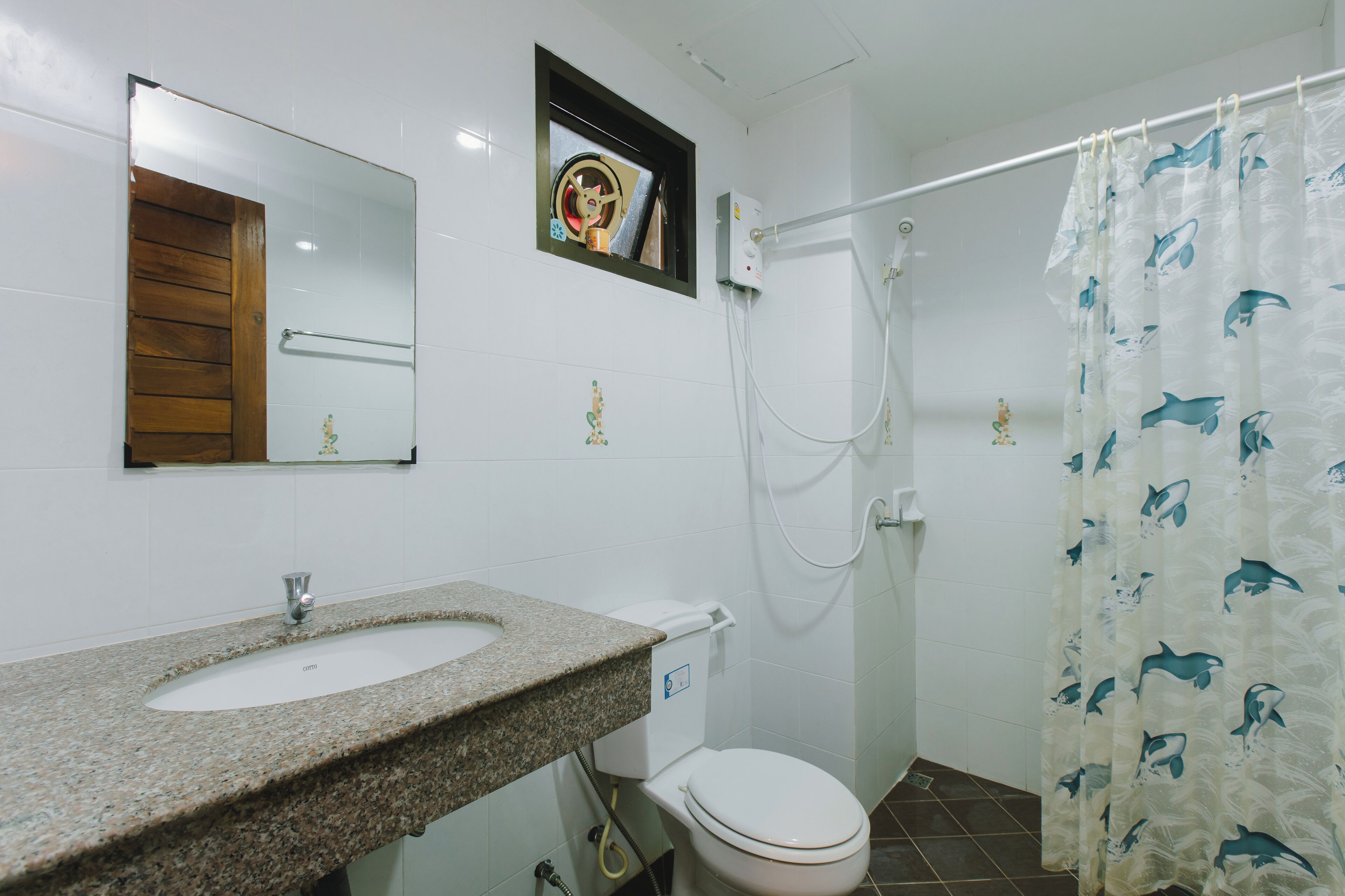 A bathroom with a granite sink, a toilet, and a shower.