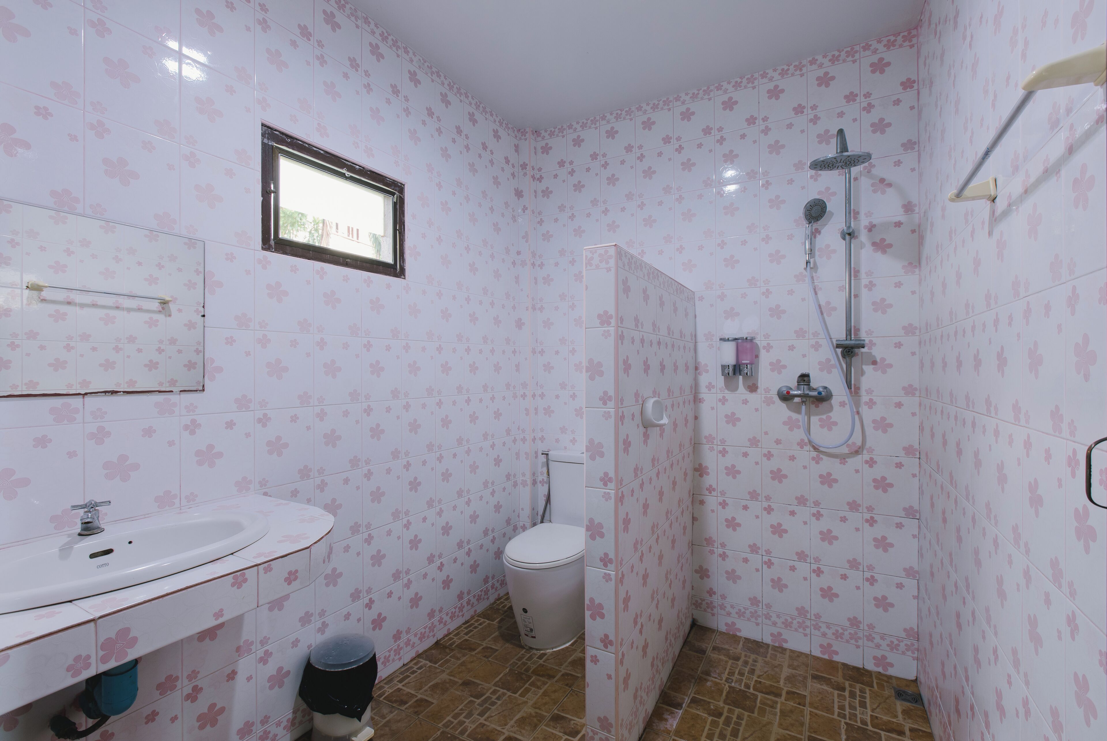 Une salle de bain avec des toilettes, un lavabo et une douche.