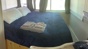 A room with a bed, a window with curtains, and a view of the outside. - Wake up on the Lake! … Gate Keeper (Port Clinton)