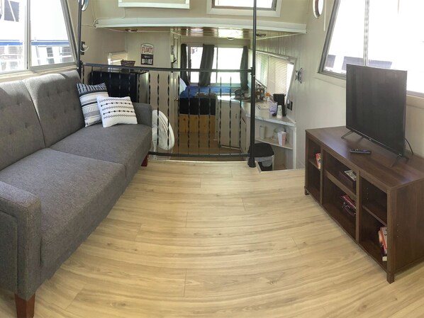 A compact living area with a sofa, a TV, and a wooden cabinet. - Wake up on the Lake! … Gate Keeper (Port Clinton)