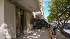 Une façade d’immeuble propre et moderne, dotée de grandes fenêtres et d’un balcon.
