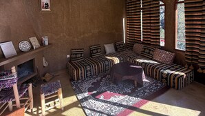 Un salon chaleureux avec un ensemble de canapés, un tapis à motifs et une petite table en bois.