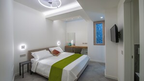 A modern bedroom with a bed, bedside table, and a desk with a chair. - Villa Corito, luxury villa on the Amalfi coast (Campania)