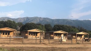 A row of wooden cabins with a mountain backdrop. - Les Chalets de Tesa N°2 Luxe, Calme et Nature (Occhiatana)