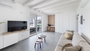 A modern living room with a flat-screen TV, wooden coffee table, and a beige sofa with decorative pillows. - La Cittadella PT-6 by Wonderful Italy (Manerba del Garda)