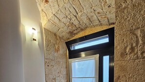 A room with exposed stone walls, a skylight, and a wooden floor. - PietraRosa Apartment (Triggianello)