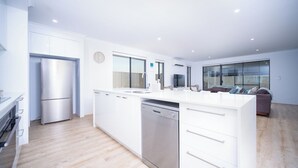 A modern kitchen with white cabinetry, stainless steel appliances, and a dishwasher.
