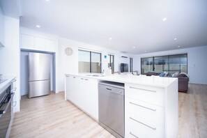 A modern kitchen with white cabinetry, stainless steel appliances, and a dishwasher. - ShoreAcres Retreat—Peaceful Beach Hideaway (Dunsborough)