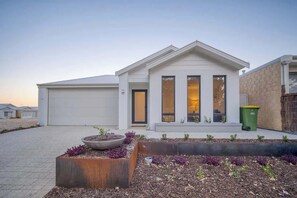 A modern house with a garage, a front porch with a bench, and a landscaped garden area. - Shoreacres Retreat - Your next holiday in paradise (Dunsborough)