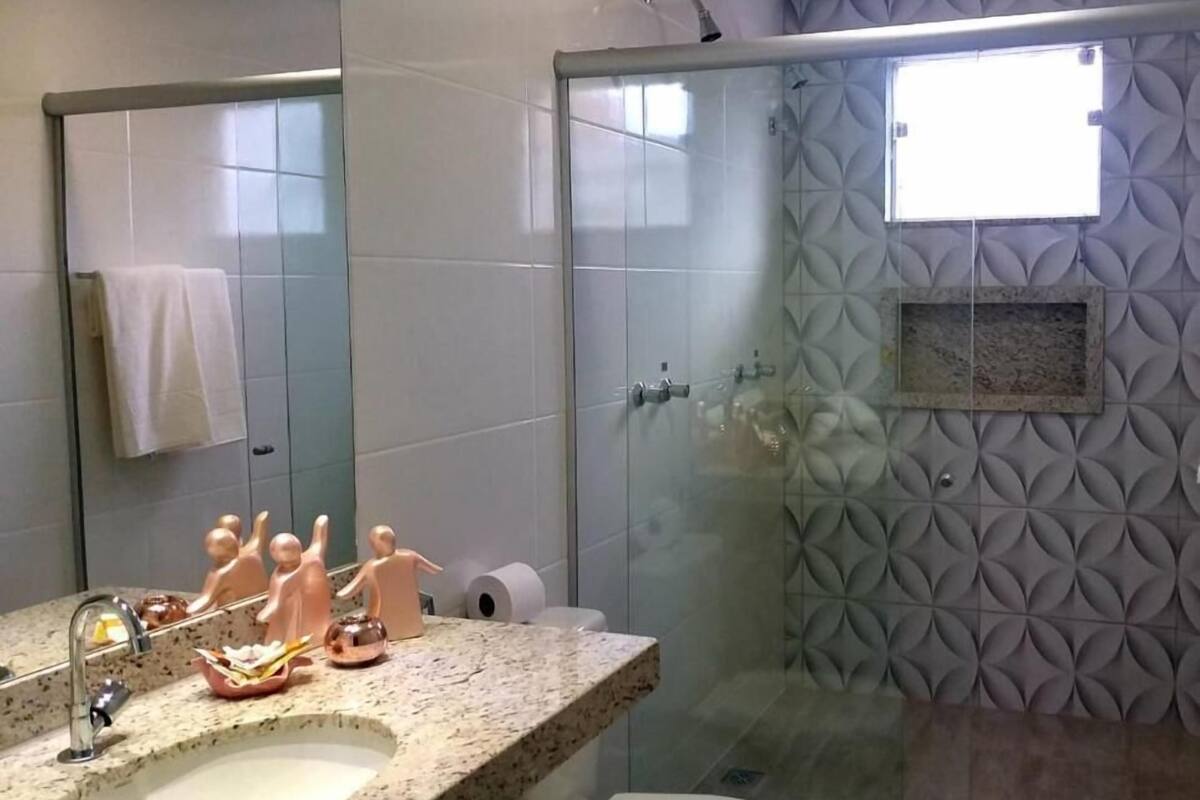Ein modernes Badezimmer mit einem Granittisch, einer Toilette und einer Duschkabine aus Glas.