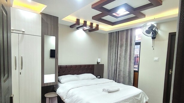 Un dormitorio con cama, armario, mesita de noche y ventilador de techo.