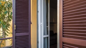 Una porta con maniglia in metallo, un tappetino decorativo e un pavimento piastrellato.