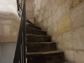 A staircase with a metal handrail leading to a door.