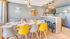 A modern kitchen with a central island, a dining area with yellow chairs, and a large window with curtains. - 200m from ski slopes, 2nd floor, balcony, ski locker, 120m², Tignes (Tignes)