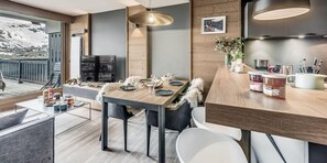 A modern dining area with a wooden table set for two, a television, and a view of the outdoors. - 200m from resort center, 1st floor, ski locker, 50m², Tignes (Tignes)
