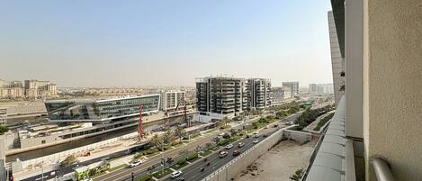 A cityscape with modern buildings, a river, and a busy road.