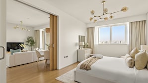 A modern hotel room with a large bed, a desk, a TV, and a city view. - Silkhaus AL Sana 2 - AL Raha (Abu Dhabi)