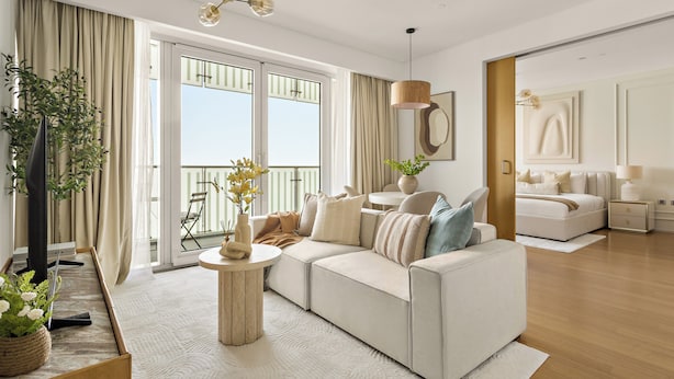 A modern living room with a sofa, a round coffee table, a potted plant, and a large window with curtains. - Silkhaus AL Sana 2 - AL Raha (Abu Dhabi)