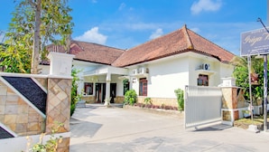A hotel with a tiled roof, a gated entrance, and a signboard. - Hotel O Syariah Griya Wisata (Wonogiri)