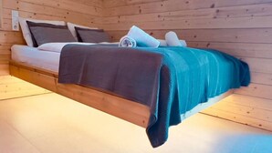 Een bed in een houten kamer met een schuine kap.