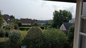 A view from a window overlooking a residential area with houses, greenery, and a clear sky. - Maison Dans Lotissement Très Calme 300 Mètres du Centre Ville .10 km de la mer (La Haye)