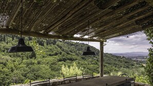 An outdoor seating area with a pergola, stone railings, and a view of a lush green hillside. - Villa in Villamagna with 6 bedrooms sleeps 12 (Villamagna)