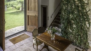 A dining area with a wooden table and chairs, a stone wall with ivy, and a view of a garden through an open door. - Villa in Villamagna with 6 bedrooms sleeps 12 (Villamagna)