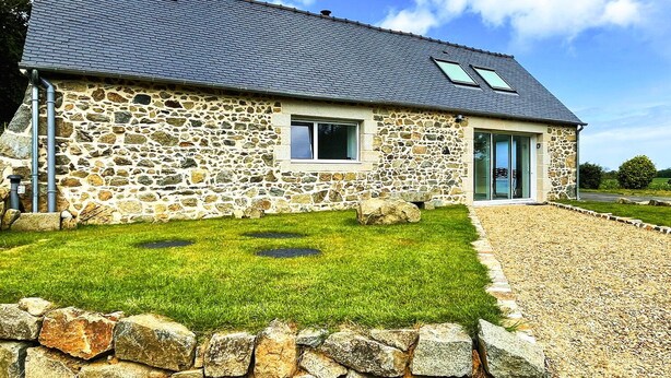 A stone house with a sloped roof, a gravel driveway, and a grassy lawn. - House Le Rohel (Pleubian)