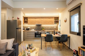 Eine moderne Küche mit Einbauofen, Kühlschrank und Essbereich mit Tisch und Stühlen.