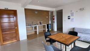 A modern kitchen with a wooden countertop and a built-in oven. There is a dining area with a wooden table and four chairs. - Black Pearl (Puerto Villamil)