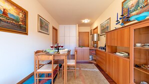 Una cocina funcional con armarios de madera, una mesa de comedor con sillas y una pequeña isla.