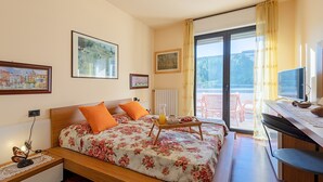 Un dormitorio con una cama, un escritorio y vistas al exterior.