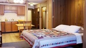 A bedroom with a bed, a wooden headboard, a ceiling fan, and a nightstand.