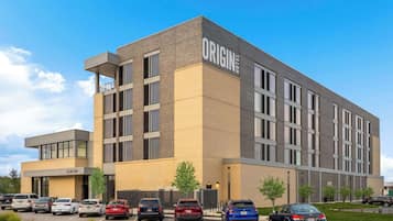 Un hôtel moderne, reconnaissable à son enseigne bien visible où l’on peut lire « ORIGIN HOTEL ».