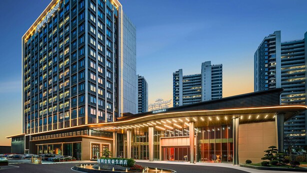 A high-rise hotel with a modern design, featuring a prominent entrance and a well-lit facade. - Howard Johnson Royal Hotel Shenzhen (Shenzhen)