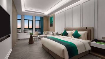 Habitación de hotel moderna con una cama grande, un escritorio y vistas a la ciudad a través de amplios ventanales.
