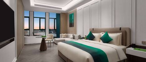 A modern hotel room with a large bed, a desk, and a view of the cityscape through large windows.