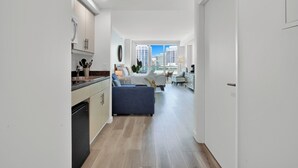 Un appartement moderne doté d’une cuisine, d’un espace de vie et offrant une vue sur la ville.