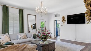 Una sala de estar con un sofá, una mesa de centro y un televisor montado en la pared.