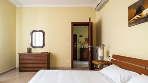 A bedroom with a bed, dresser, and a mirror. - San Donato Cozy Apartment by Wonderful Italy (Bologna)