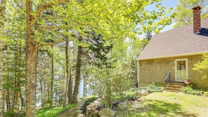 A house with a stone exterior, a brick chimney, and a stone pathway leading to the front door. - Serene Steuben Home w/ Scenic Ocean Views! (Steuben)