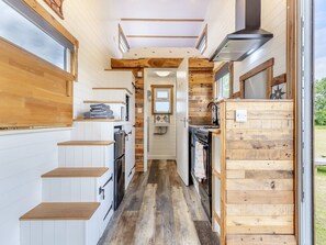 Una cocina compacta con armarios de madera, horno empotrado y estufa.