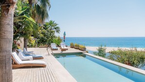 A poolside area with lounge chairs and a view of the ocean. - Villas La Mar (Todos Santos)
