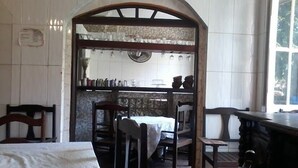 A traditional dining area with a high wooden archway, a tiled backsplash, and a view of the kitchen. - CASADALUCIA  POUSADA (Salvador)