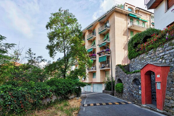 A multi-story residential building with balconies, a stone wall, and a narrow street. - Stunning Sea View Apartment with Terrace in Camogli by Wonderful Italy (Camogli)