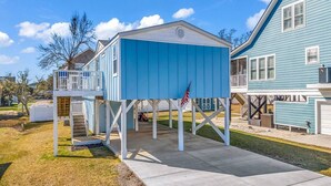 A blue house with a covered porch and a flagpole. - Blue Sky Ranch-walk to beach! Sleeps 6 (Murrells Inlet)
