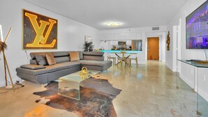A modern living room with a sectional sofa, a glass coffee table, and a cowhide rug. - Zeus Sanctuary in Brickell Miami (Miami)