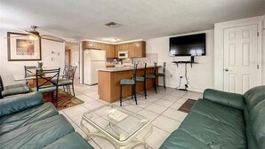 A compact living space with a kitchenette, a dining area, and a seating area with a sofa and chairs. - Kick back and Relax at Leisure Beach (Hudson)