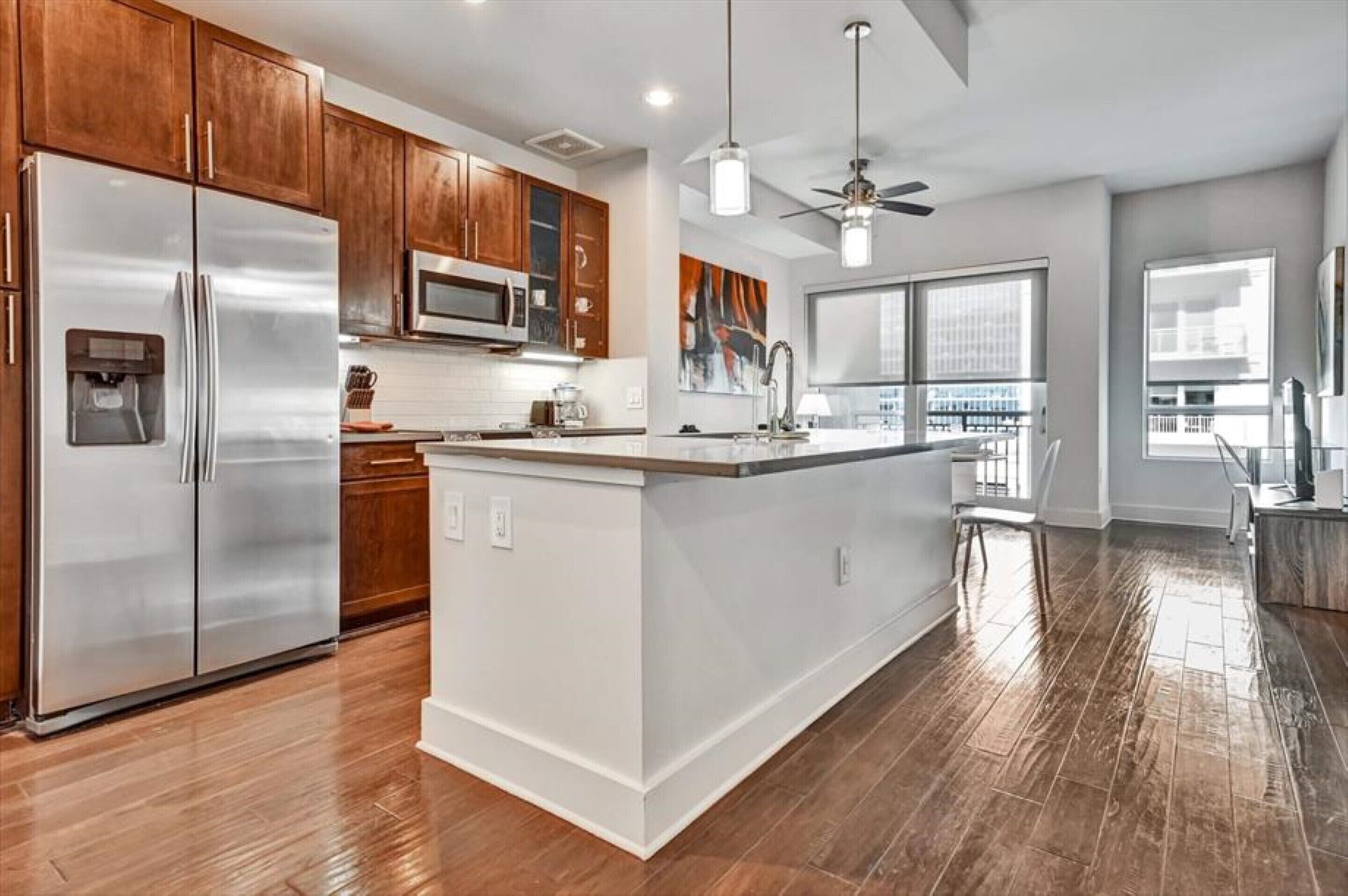 A modern kitchen with wooden cabinets, stainless steel appliances, and a large island.