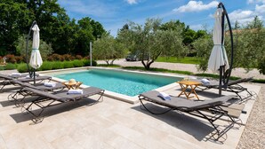 A rectangular swimming pool with lounge chairs and umbrellas. - Holiday Home Olea - 3 Bedrooms (Labin)